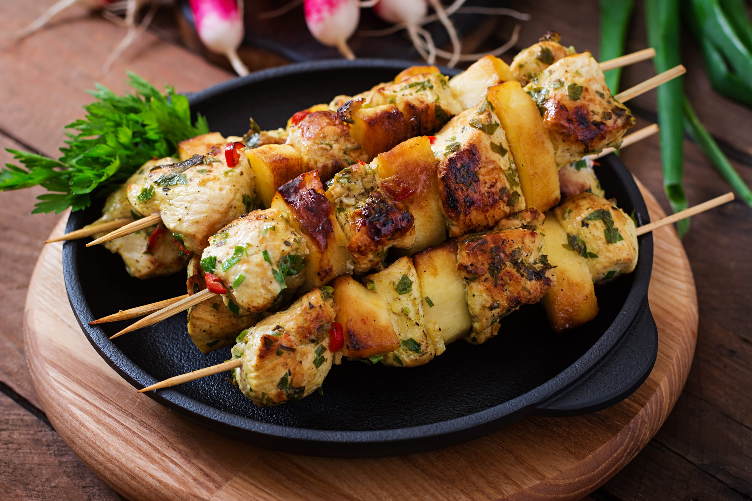 chicken skewers with slices of apples and chili